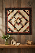 Baby Diamond Daze quilt hanging on rustic wooden wall with mason jar greenery and stuffed bunny